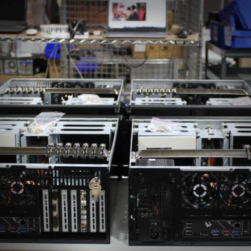 A group of computers sitting on a table in a factory.