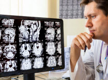 A doctor looking at mri images on a computer screen.