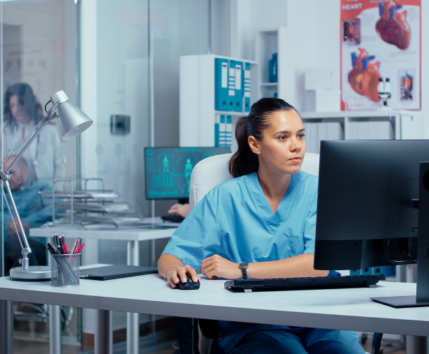 A nurse is sitting at a healthcare desk.