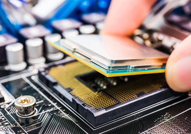 A hand is carefully placing a computer processor onto a motherboard socket, paving the way for future advancements in computational physics.